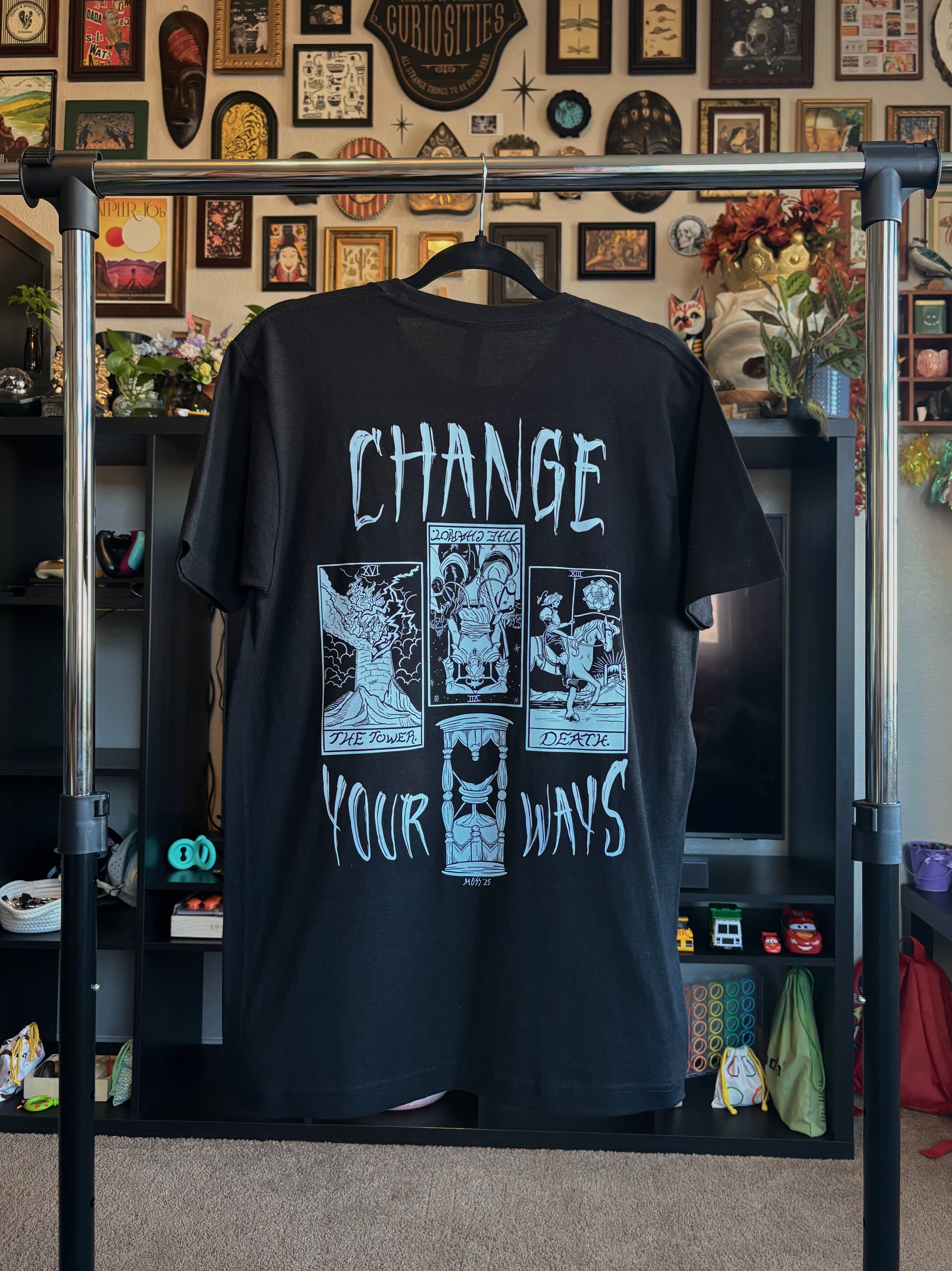 black t-shirt with the Change Your Ways tarot inspired design hanging on a rack to show the full back print