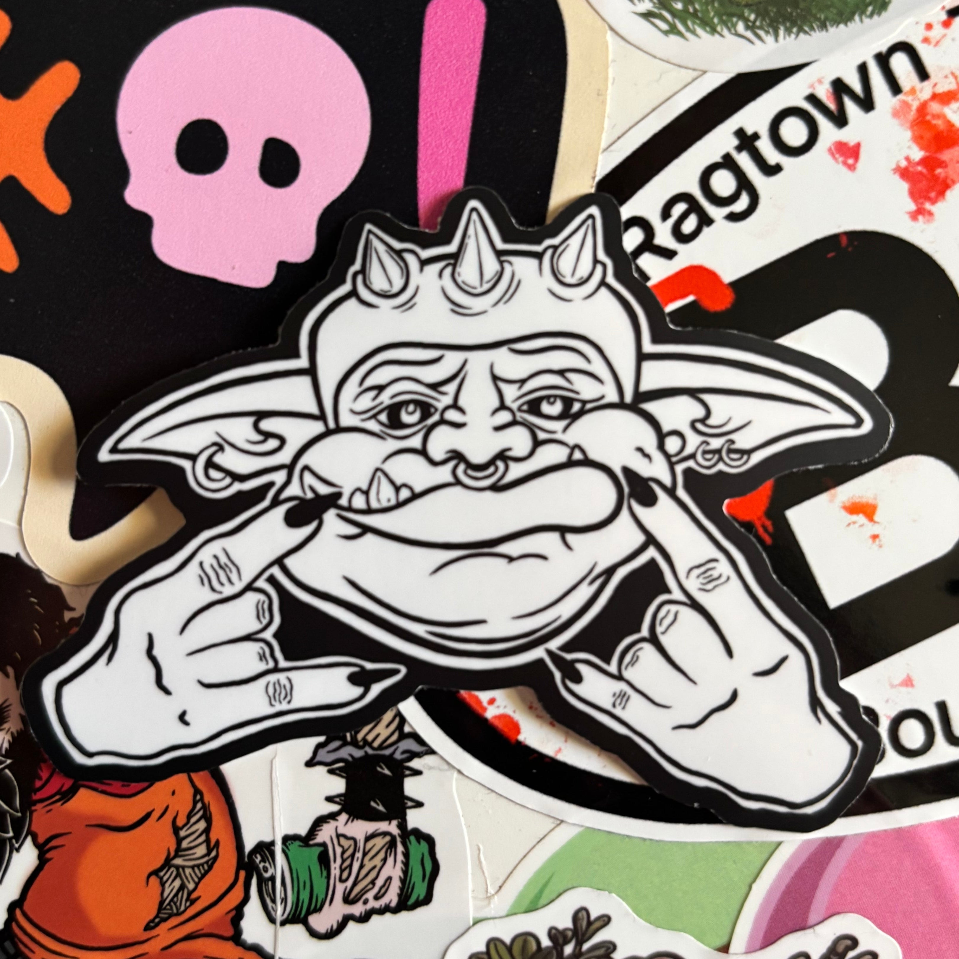 a black and white sticker of "Frankie" from the Goblin Gang, holding up his hands in the "Rock On" gesture 