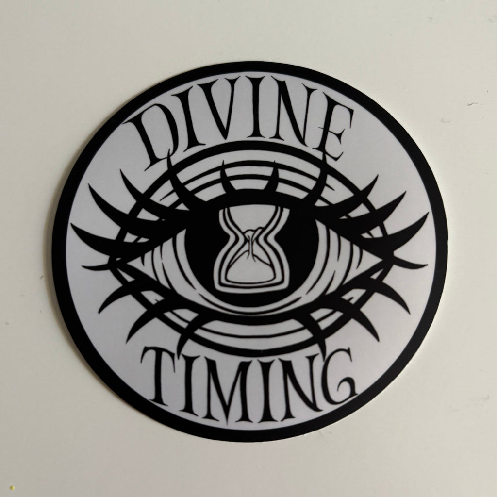 the Divine Timing Hourglass Eye logo printed as a black and white sticker