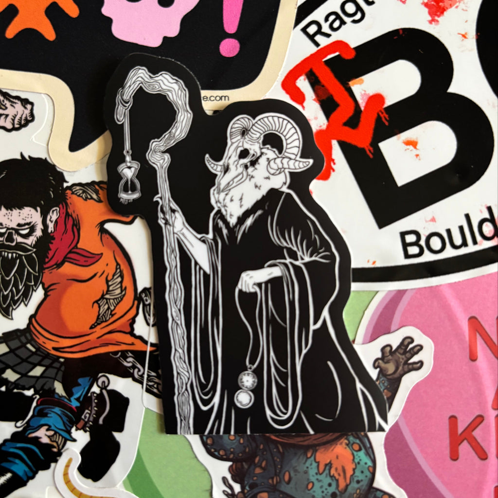 sticker of a spooky figure with a ram's head, holding a crooked staff, an hourglass, and a pocket watch.