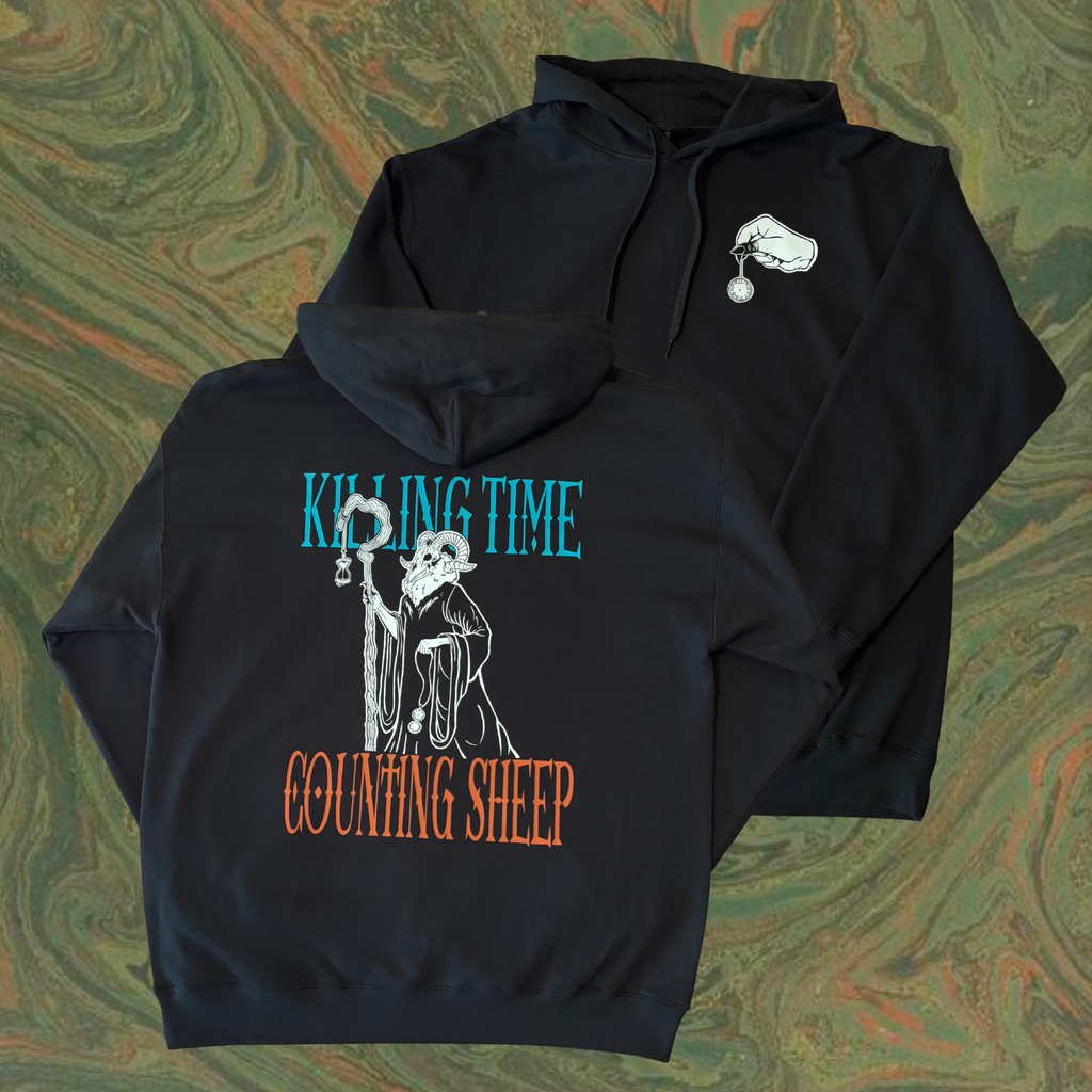 black hoodie with 'Killing Time' across the top and 'Counting Sheep' across the bottom, surrounding an eerie figure with a ram's head who holds a staff, an hourglass, and a pocket watch