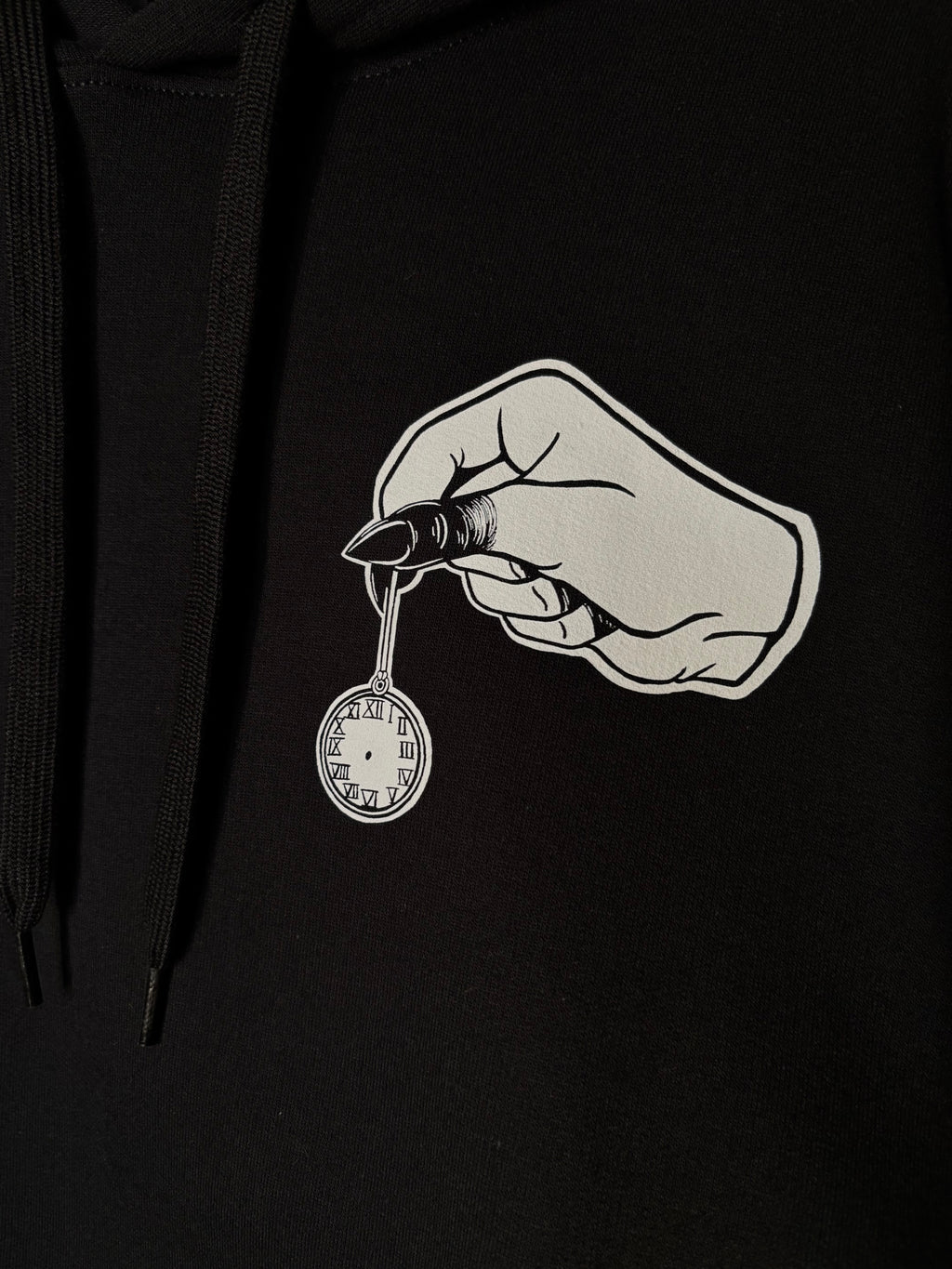 closeup look at the club patch on the front of the Killing Time design, which shows a hand with blackened fingers holding a small pocket watch