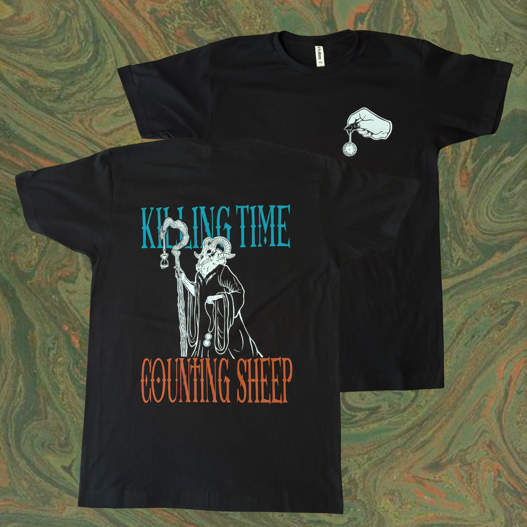 black t-shirt with a graphic design. 'Killing Time' printed across the top of the back and 'Counting Sheep' across the bottom, surrounding an eerie figure with a ram's head who holds a staff, an hourglass, and a pocket watch