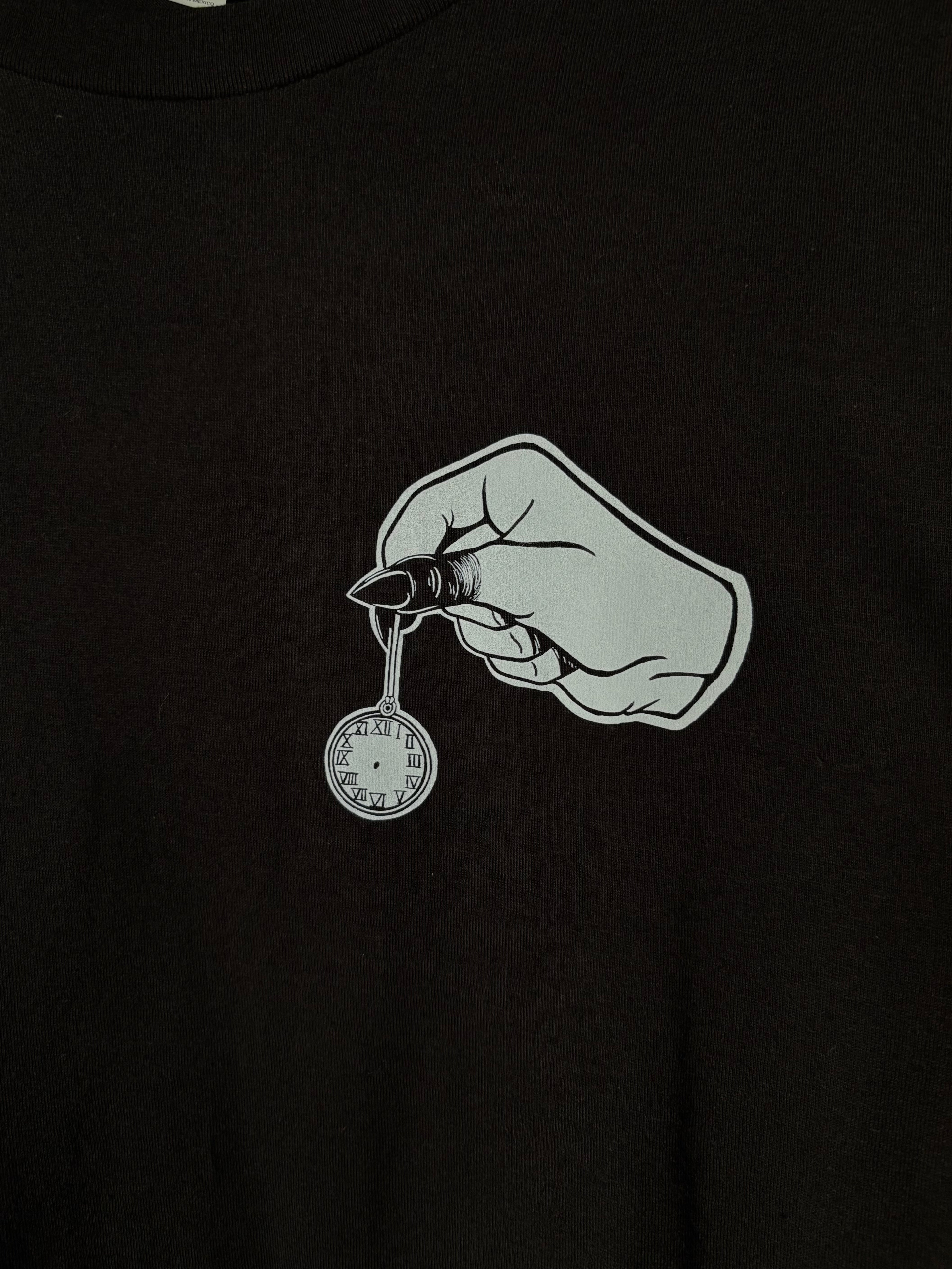 closeup look at the club patch on the front of the Killing Time design, which shows a hand with blackened fingers holding a small pocket watch