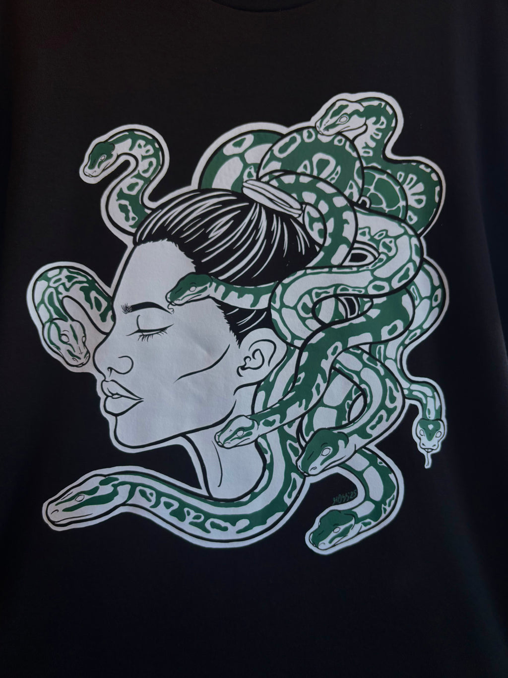 closeup look at the Medusa print on the front of a black t-shirt