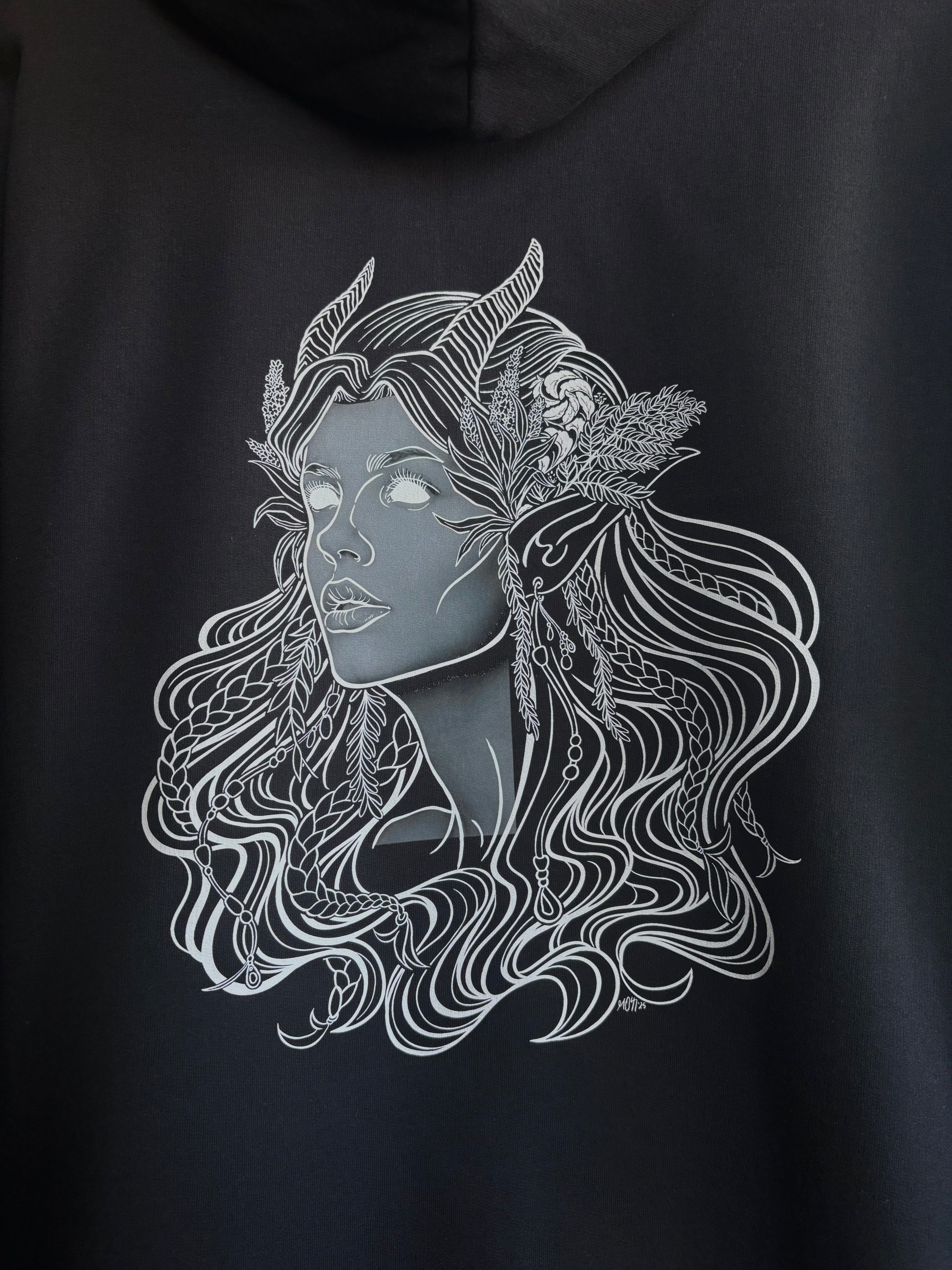 closeup look at the Queen of the Forest printed on the back of a black hoodie